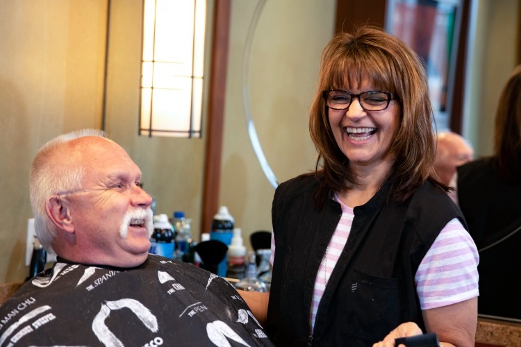 Staff member getting hair cut