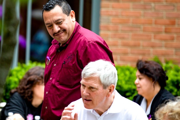 Waiter smiling at members outside