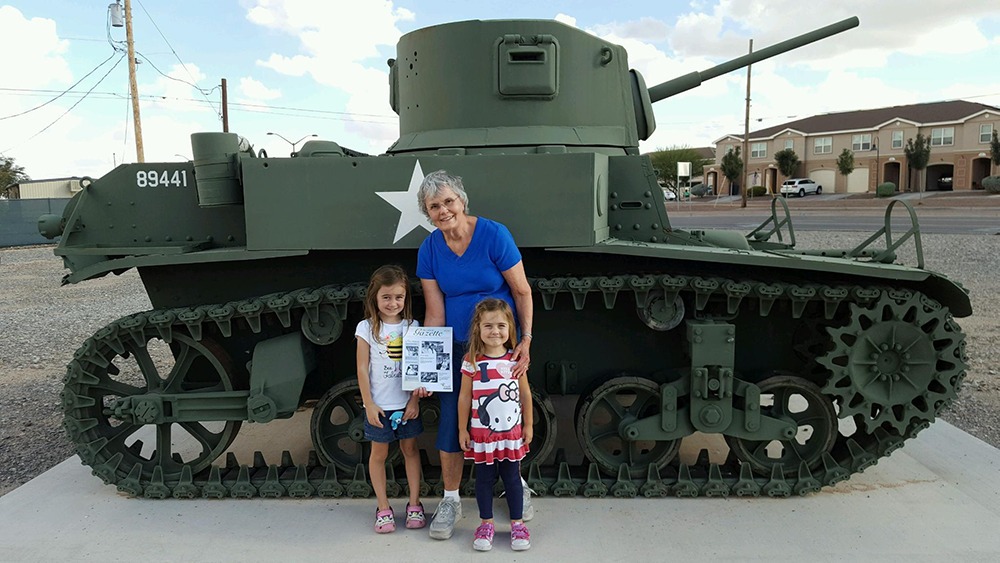 Joyce and her grandchildren in front of an army tank