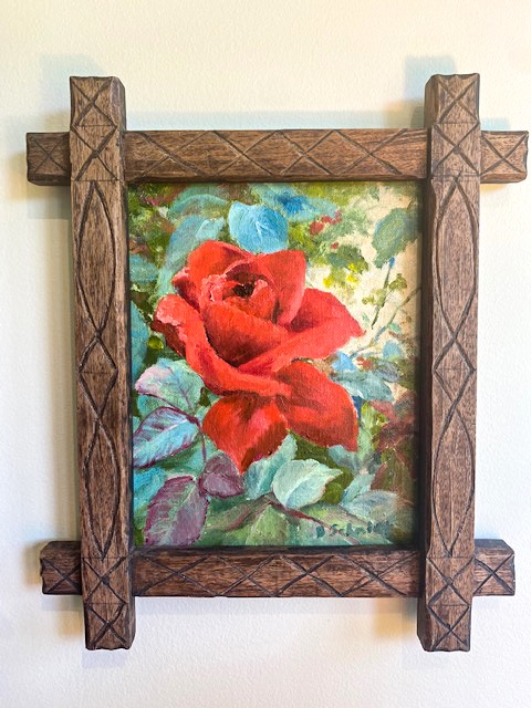 Rose painting in a wood carved frame.