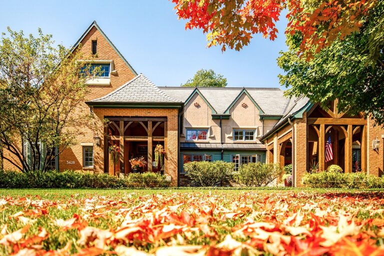A Garlands Villa with fall leaves on the ground and tree changing colors