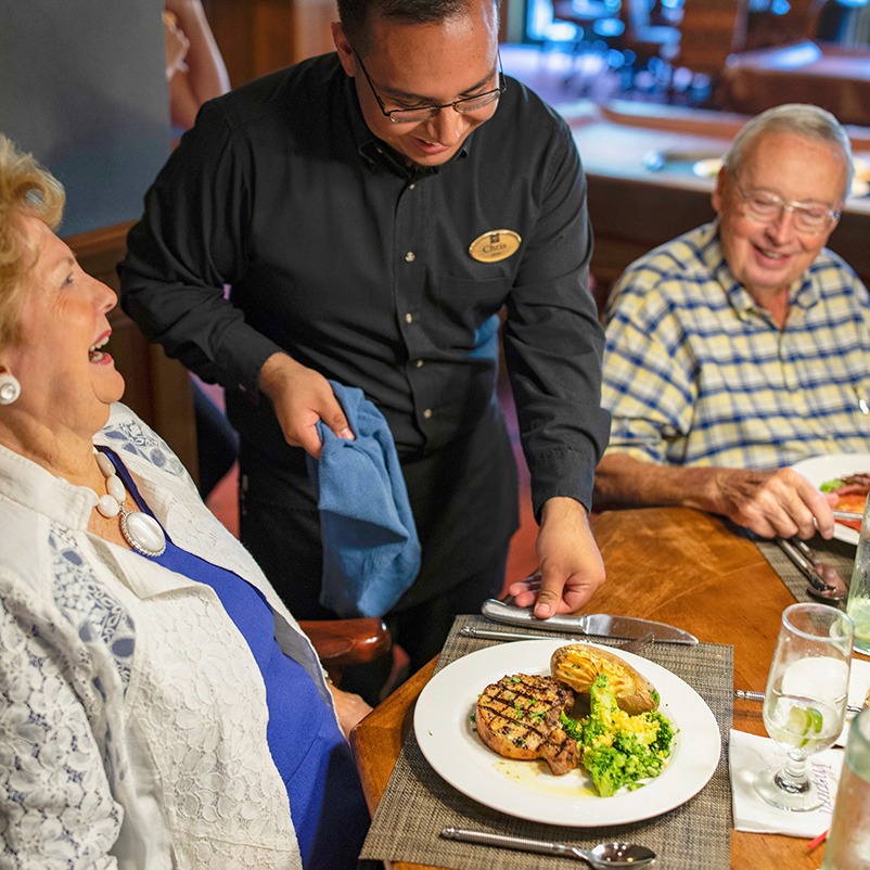 Garlands waiting staff serves an entree to a member