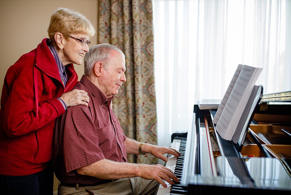 Oliver playing the piano as Barb watches