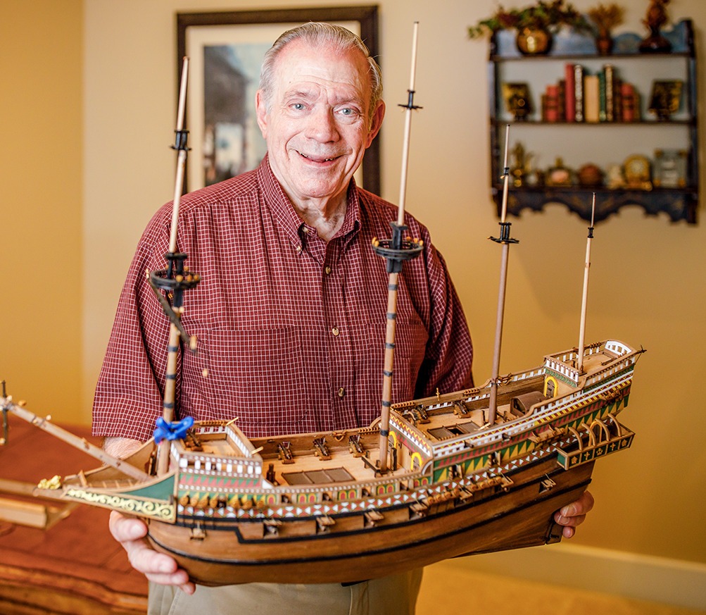 oliver holding a detailed model of a ship he created