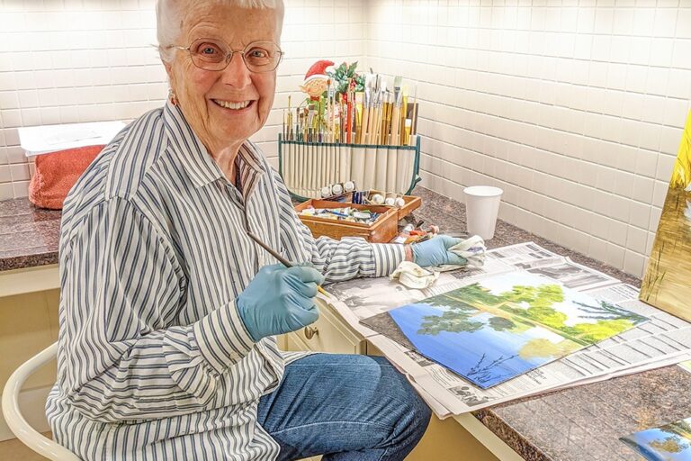 Marlene Peterson painting in her kitchen