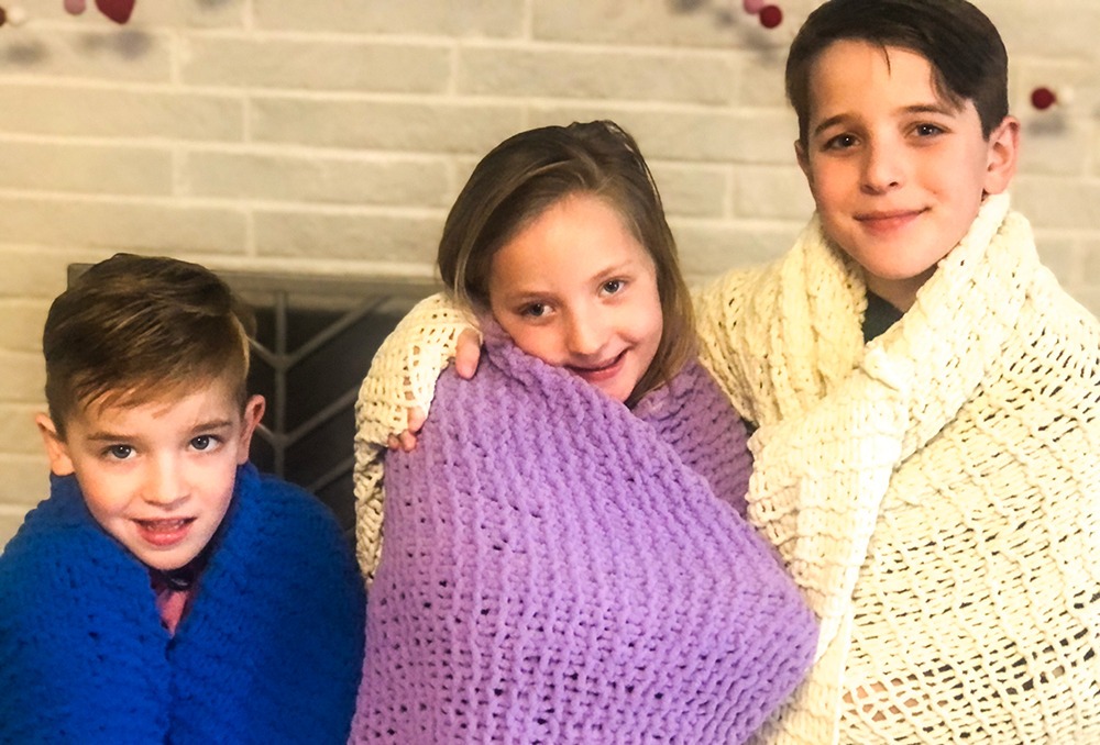 Grandchildren with knitted blankets