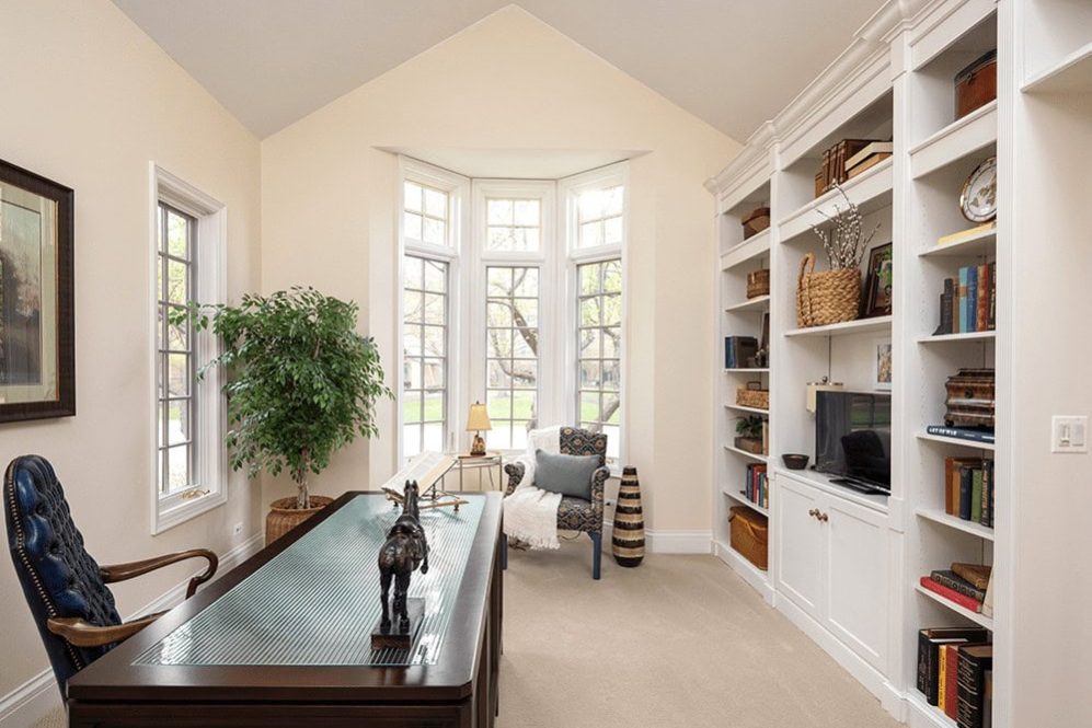 Villa den with tall windows and book cases