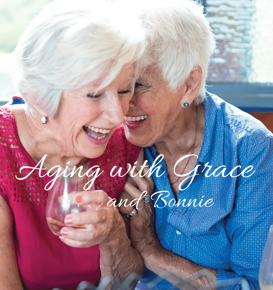 Two woman sharing a glass of wine and laughing together