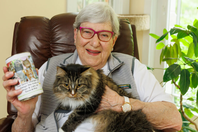 Lee Heckmeck with her cat and donation can