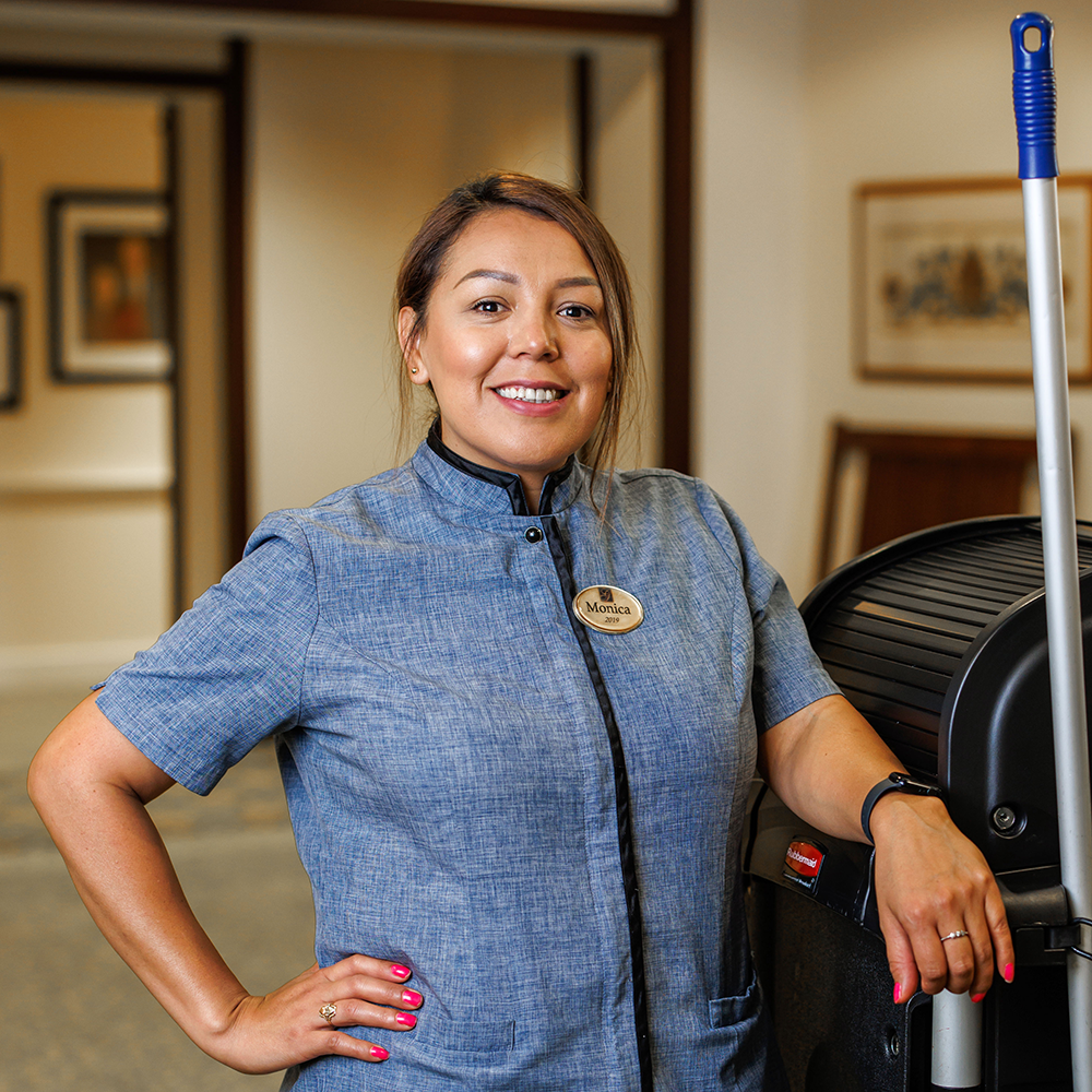 Staff standing next to the cleaning cart smiling