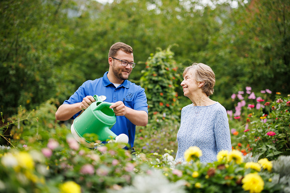 Staff watering flowers for a Garlands Member