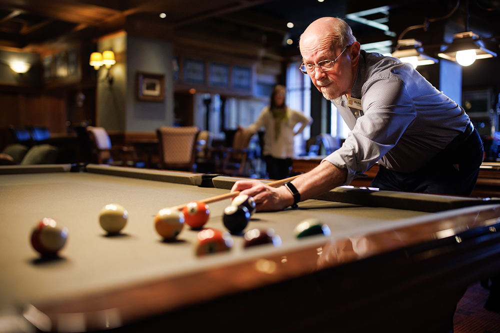 Member lining up a shot in a game of pool