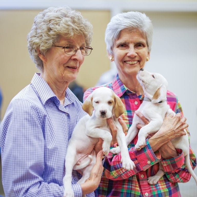 Two Garlands Members holding puppies