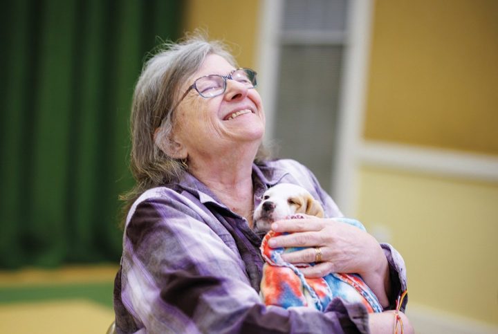A Garlands member enjoying a snuggle with a puppy.