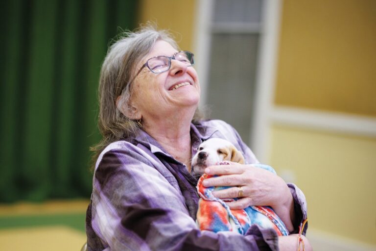 A Garlands member enjoying a snuggle with a puppy.