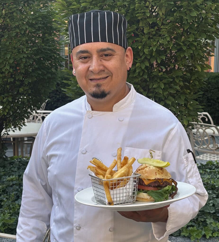 Chef holding the winning best burger with bacon and a pickle