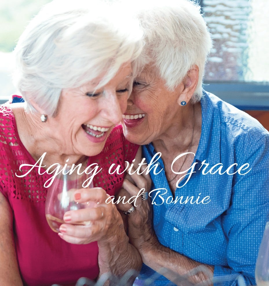 Two woman sharing a glass of wine and laughing together