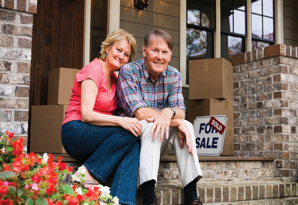 Couple with a sold house sign